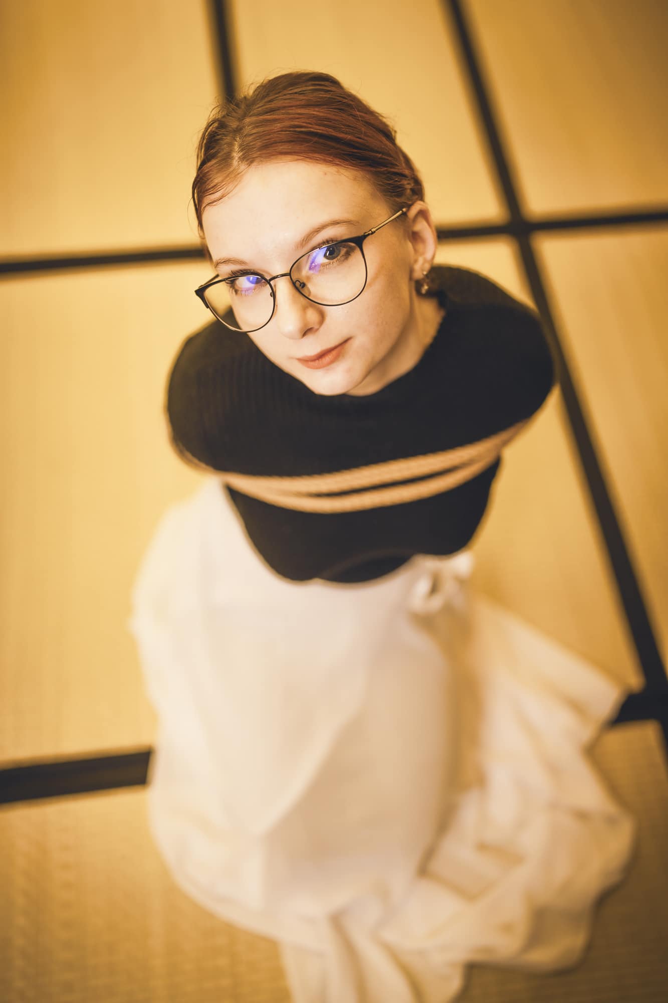 Myu z AKD v černém roláku a světlé sukni stojí v dojo prostoru, ruce sepnuté u brady, při průběhu workshopu.