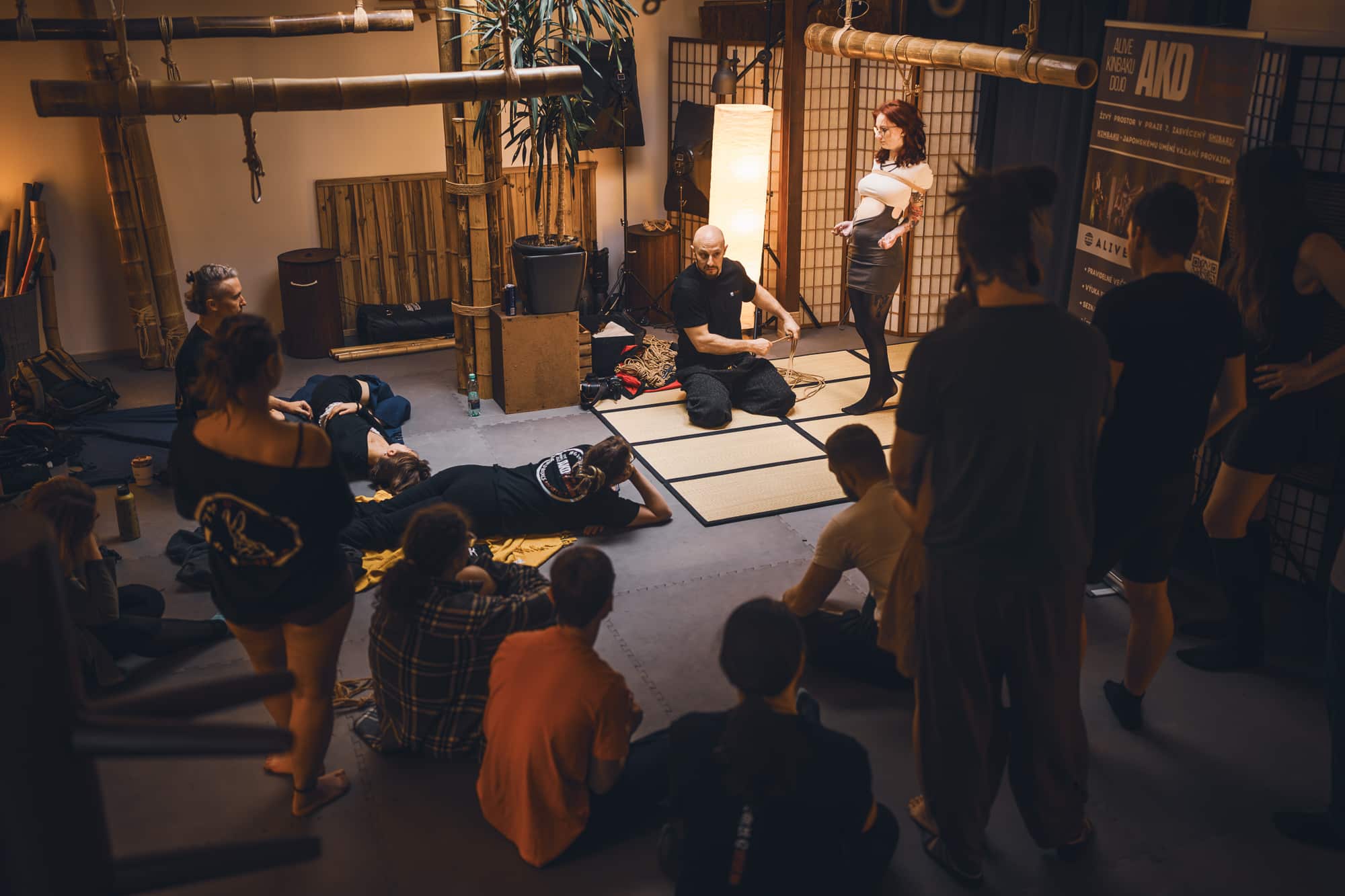 Myu s brýlemi leží na boku na tatami, unavená po intenzivní praxi na workshopu.
